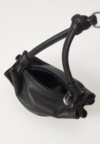 Black leather handbag with a gathered design, featuring a zippered opening and a curved handle. Minor stitching details visible.