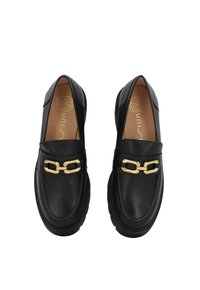 Mocassini in pelle nera con dettaglio in catena dorata, punta arrotondata e suola in gomma spessa. Texture liscia con sottili dettagli di cucitura.