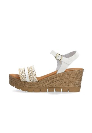Weiße Keilsandalette mit geflochtenem Frontriemen, Knöchelriemen mit goldener Schnalle und strukturierter brauner Plateau-Sohle.