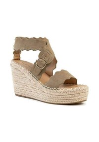 Sandale compensée beige avec un dessus en suède texturé, des brides ondulées et une boucle ajustable, complétée par une semelle en jute tressé.