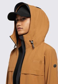 Brown waterproof jacket with a hood and zip closure, featuring a black inner layer, logo details, and adjustable drawstring.