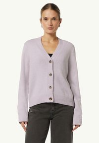 Lila Strickjacke mit V-Ausschnitt, gerippten Bündchen und fünf braunen Knöpfen auf der Vorderseite. Weicher Stoff, cropped Länge.