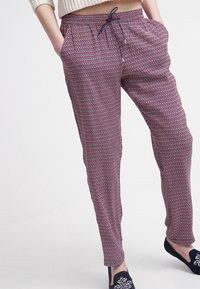 Rode en marineblauwe joggerbroek met een elastische tailleband, trekkoordsluiting en zijzakken. Lichtgewicht stof met een relaxte pasvorm.