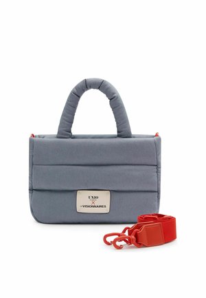 Sac à main matelassé gris avec poignées supérieures, une étiquette rectangulaire et une sangle détachable rouge vif avec clips à côté.