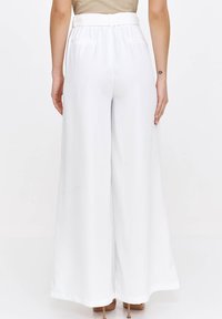 Białe spodnie w szerokim kroju, o gładkiej fakturze, wysokim stanie i tylnych kieszeniach. Projekt charakteryzuje się czystą, płynącą sylwetką oraz dopasowanym wykończeniem.
