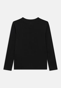 Mustast pehmest materjalist pikem varrukatega särk, millel on ümarsärk ja lihtne disain ilma mustrite või kaunistusteta.