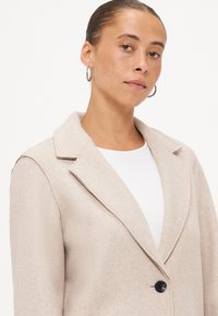 Licht beige, op maat gemaakte wollen blazer in een mengsel met een notch-kraag, enkele knoopsluiting en een minimalistisch ontwerp. Gladde textuur, getailleerde pasvorm.