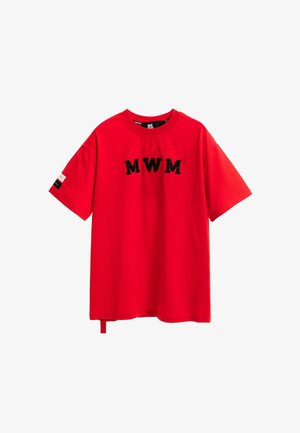 Camiseta roja de gran tamaño hecha de algodón, con letras negras "MWM", mangas cortas y una pequeña etiqueta de contraste en la manga izquierda.