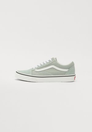 Grüne Wildleder-Sneaker im Low-Top-Stil mit weißen Seitenstreifen, schwarzer Gummisohle und weißen Schnürsenkeln. Mit einem Logo auf der Ferse und gesteppten Akzenten.