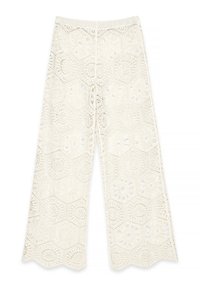 Pantaloni larghi all'uncinetto di colore bianco sporco, con ritagli esagonali e motivi floreali, orlo ondulato e vita elastica.