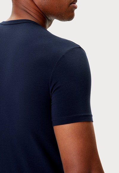 Granatowy, krótkim rękawem t-shirt o dopasowanym kroju, gładkiej fakturze i okrągłym dekolcie. Proste, czyste linie bez widocznych wzorów lub ozdób.