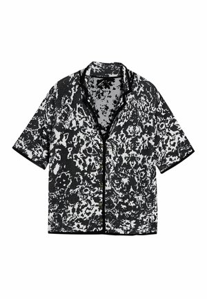Korte mouwen shirt met een zwart-wit abstract patroon, knoopsluiting aan de voorkant en kraag. Gemaakt van gestructureerde stof met contrasterende afwerking.