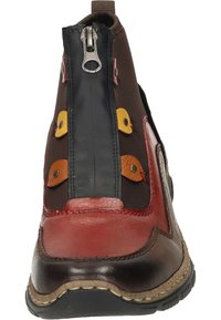 Bottines en cuir marron et rouge avec une fermeture éclair à l'avant, des accents décoratifs en jaune et marron, et une semelle en caoutchouc texturée.