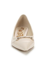 Ballerines en cuir verni beige à bout pointu, avec un accent métallique sur le devant, texture lisse et semelle intérieure rembourrée pour un confort optimal.