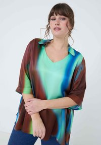 Silky, oversized, V-neck shirt featuring a gradient pattern of green, blue, and brown shades with a loose, flowing fit and elbow-length sleeves.