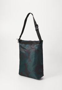 Borsa a tracolla di colore verde scuro con un motivo a foglie. Realizzata in tessuto con una superficie liscia. Presenta una tracolla nera regolabile e una chiusura con zip.