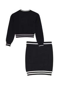 Set composto da maglione cropped nero e gonna abbinata, con strisce bianche sui polsini e sull'orlo della vita. Tessuto a maglia morbido con una consistenza liscia.