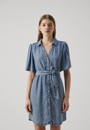Denim srajčna obleka s kratkimi napihnjenimi rokavi, ovratnikom, sprednjimi gumbi in vezanim pasom. Ima svetlo modro barvo in sproščen kroj.