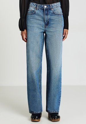 Jeans a vita alta e gamba larga in denim azzurro chiaro, con chiusura a bottoni, cinque tasche e una texture leggermente scolorita.