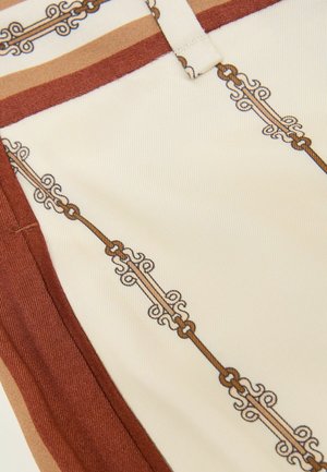 Material crem cu margine decorativă cu model de lanțuri și volute în culori maro și bej.