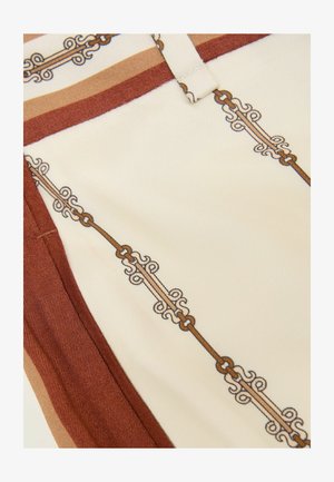 Material crem cu margine decorativă cu model de lanțuri și volute în culori maro și bej.
