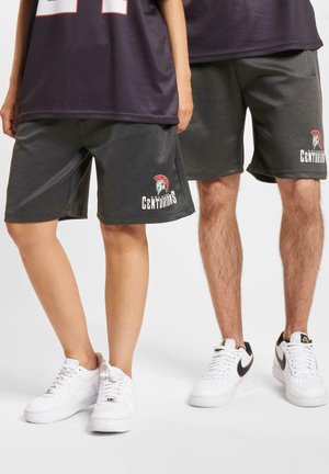 Shorts atletici gri cu logo-ul "Centurions" și un grafic cu un căpăstru spartan. Asortați cu adidași albi, cu accente negre și talpă texturată.