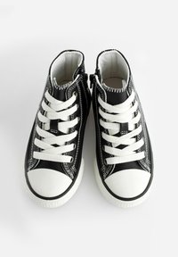 Schwarze Leder High-Top Sneaker mit weißen Schnürsenkeln, Gummikappen, weißen Nähdetails und seitlichen Reißverschlüssen für einfaches An- und Ausziehen.