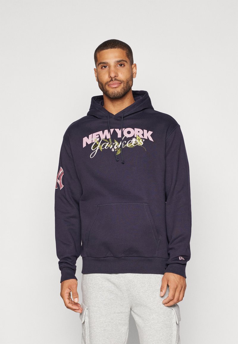 Marineblå hættejakke med frontlomme, prydet med "NEW YORK Yankees" grafik i pink og grøn. Har ribbede manchetter og hætte med snøre.
