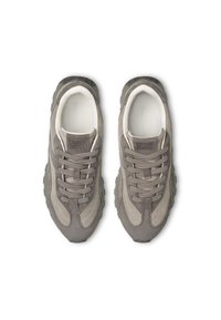 Sneaker in suede grigio con un design a strati, dettagli testurizzati, lacci rotondi e suola imbottita. Nome del marchio visibile sulla linguetta.