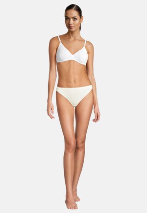 Weißer nahtloser Bralette und hellcremefarbene Bikiniunterteile. Glatter Stoff, minimalistisches Design, V-Ausschnitt-BH und bequemer Bund.