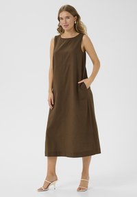 Robe sans manches marron avec une coupe décontractée, dotée de poches latérales et d'un ourlet droit. Texture lisse et détails de couture minimalistes.