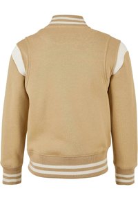 Tan sweatshirt med hvide stribede ribbestrikkede detaljer på kraven og ærmerne. Glat tekstur og simpelt design med farveblok accenter på skuldrene.