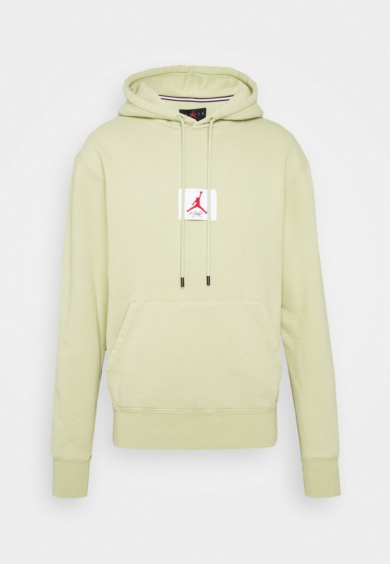 Sudadera verde claro con un bolsillo tipo canguro en el frente y capucha con cordón. Presenta un parche blanco con un logo rojo y texto en el pecho.