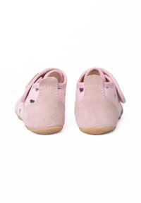 Różowe zamszowe buty o miękkiej fakturze, z rzepem i kolorowymi wzorami, uzupełnione gładką gumową podeszwą.