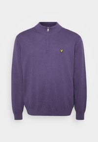 Purple knit sweater with a high collar and half zip, featuring a small yellow embroidered logo on the left chest. Soft texture.