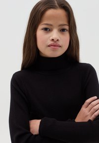 Schwarzer, gerippter Pullover mit hohem Kragen und langen Ärmeln, in einer taillierten Silhouette und aus strukturiertem Stoff.