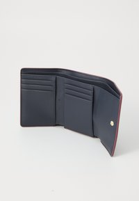 Námořnická kožená peněženka s burgunským lemem, která má více slotů na karty a uzávěr na knoflík. Hladká textura, minimalistický design.