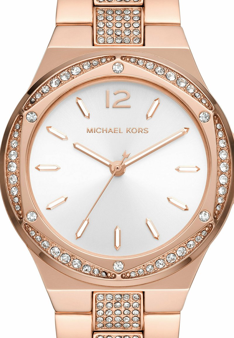 Różowe złoto zegarek na rękę Michael Kors z kryształową obręczą i ogniwami bransoletki, srebrna tarcza oraz minimalistyczne znaczniki godzin i wskazówki.