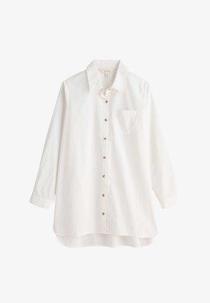 Camisa blanca de manga larga con botón y cuello, con un bolsillo en el pecho y bajo redondeado. Presenta botones en tono dorado a lo largo del frente.