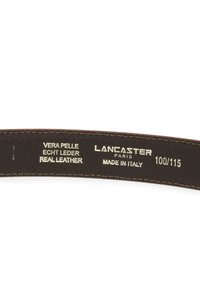 Cintura in pelle marrone con cucitura crema, caratterizzata da testo impresso: "Lancaster Paris," "Pelle Vera," e dettagli di produzione. Fabbricata in Italia.