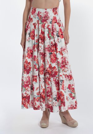 Jupe maxi florale avec une taille smockée, fond blanc avec des motifs floraux rouges et verts, volants en bas.