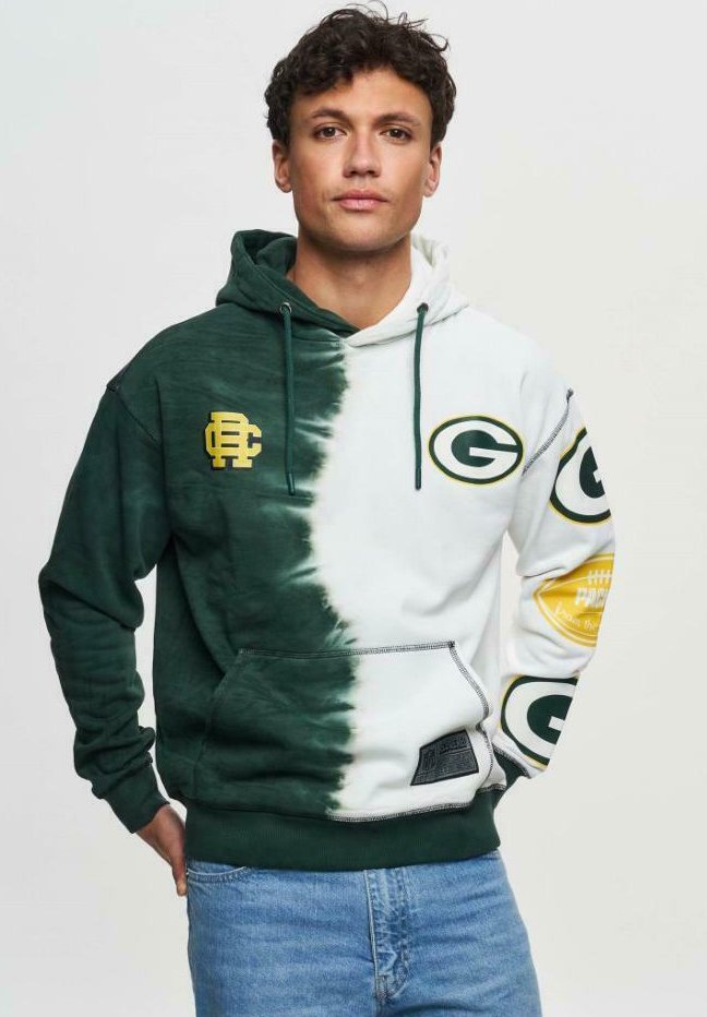 Huppari, jossa on jakautunut muotoilu; vasen puoli tummanvihreä, oikea puoli valkoinen. Siinä on vihreät ja kultaiset logot, säädettävä naru ja etutasku.