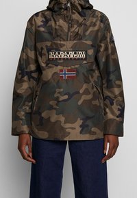 Kurtka w wzór kamuflażu z kapturem, wykonana z lekkiego materiału. Posiada kieszeń z przodu, naszywkę z logo oraz akcent w postaci flagi norweskiej.