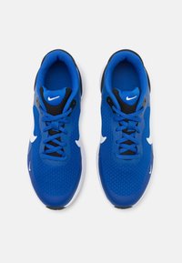 Chaussures de sport bleues avec une tige en mesh, accents noirs, logo de swoosh blanc, design à lacets et semelle blanche rembourrée.