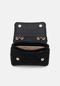 Borsa a tracolla in tessuto nero con finiture oro, dotata di chiusura a pattina e due scomparti interni. Superficie testurizzata con una finitura morbida.