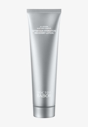 Tubo de plástico plateado con base redonda, tapa de rosca y acabado mate. Etiquetas con texto blanco: "12% Ectoin", "Complejo de Aloe Vera" y "Loción de recuperación e hidratación después del sol".