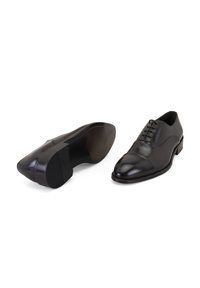 Schwarze Leder-Dress Schuhe mit glatter Oberfläche, spitzer Zehenform und Cap-Toe-Design. Verfügt über Schnürsenkel und eine flache Gummisohle für guten Halt.