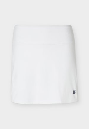 Jupe de sport blanche avec une large ceinture et un petit patch logo noir et blanc en bas à droite.