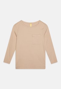 Beige langermet topp med ribbet tekstur, rund halsutskjæring og en liten brystlomme. Har en rett passform og stikninger i kantene.