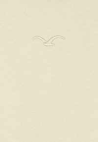 Beige cotton fabric featuring a subtle embroidered bird design at the center, giving a textured contrast to the smooth background.